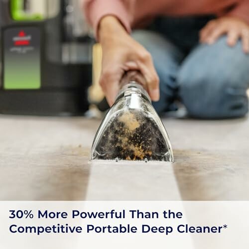 Person using a carpet cleaner on a floor.