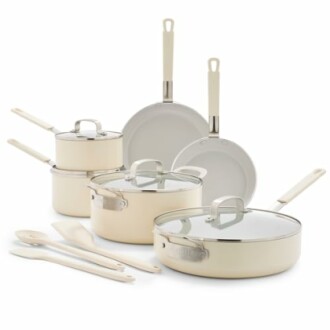 Cream-colored cookware set with pots, pans, and utensils.