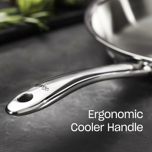 Stainless steel pan with ergonomic handle on a kitchen surface.