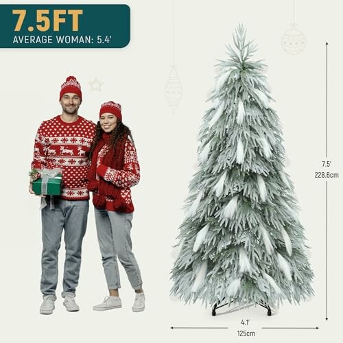 A couple in festive sweaters standing beside a 7.5-foot Christmas tree with size comparison.